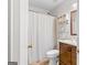 Bathroom with a white toilet and shower with neutral colored shower curtain, dark wooden vanity with mirror at 62 Cobblestone Crk, Peachtree City, GA 30269