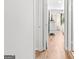 Hallway with wooden floors and white walls leads into a bright bedroom with natural light at 62 Cobblestone Crk, Peachtree City, GA 30269