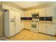 Well-lit kitchen with white appliances, tile flooring, and backsplash at 477 Harvick Cir, Stockbridge, GA 30281