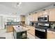 Bright kitchen with stainless steel appliances, center island, light wood cabinets, and stone backsplash at 520 Easton Dr, Locust Grove, GA 30248