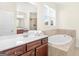 Bright bathroom featuring a soaking tub, double sink vanity, and a window for natural light at 109 Faversham Dr, Mcdonough, GA 30252