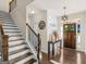 Inviting foyer featuring wood flooring, staircase, and a front door with decorative glass at 109 Faversham Dr, Mcdonough, GA 30252