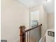 Hallway featuring a wooden railing with views into a bedroom through an open doorway at 109 Faversham Dr, Mcdonough, GA 30252