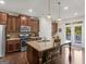 The open kitchen features stainless appliances, an island and access to the balcony at 109 Faversham Dr, Mcdonough, GA 30252