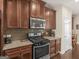 Well-equipped kitchen boasts stainless steel appliances and beautiful, rich wood cabinetry at 109 Faversham Dr, Mcdonough, GA 30252