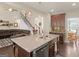 Open concept kitchen features granite island, stainless appliances, and an adjacent living space at 109 Faversham Dr, Mcdonough, GA 30252