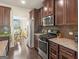 This kitchen features stainless appliances, granite counters, and rich wood cabinets at 109 Faversham Dr, Mcdonough, GA 30252