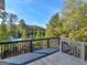 A view of the backyard from the deck featuring trees and partial view of the neighborhood pool at 109 Faversham Dr, Mcdonough, GA 30252