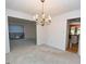 Bright dining room with chandelier, carpet flooring, and open access to other living areas at 250 Devilla Trce, Fayetteville, GA 30214