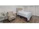 Cozy bedroom with laminate wood flooring, neutral walls, with a comfortable chair and bedside table at 2827 Somerton Dr, Morrow, GA 30260