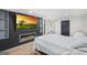 Bedroom with an electric fireplace, TV, light hardwood floors, and a dark accent wall at 2827 Somerton Dr, Morrow, GA 30260