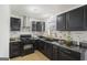 Modern kitchen features granite counters, stainless steel appliances, black cabinets and tile backsplash at 2827 Somerton Dr, Morrow, GA 30260