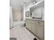 Bright bathroom featuring a shower-tub combo, granite vanity, tile floors and neutral color palette at 9135 Selborne Ln, Chattahoochee Hills, GA 30268