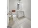 Clean, well-lit bathroom with a white vanity, modern fixtures, and a basket on the back of the toilet at 9135 Selborne Ln, Chattahoochee Hills, GA 30268