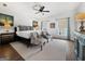 Bright bedroom featuring ceiling fan, two sitting chairs, carpeted floors and neutral color palette at 9135 Selborne Ln, Chattahoochee Hills, GA 30268