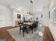 Chic dining room featuring a modern chandelier, hardwood floors, and an area rug at 9135 Selborne Ln, Chattahoochee Hills, GA 30268