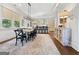 Bright dining room boasts modern chandelier, area rug, and open access to the gourmet kitchen at 9135 Selborne Ln, Chattahoochee Hills, GA 30268