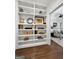 Hallway with custom built-in shelving leading into the bright, carpeted bedroom at 9135 Selborne Ln, Chattahoochee Hills, GA 30268