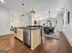 Open-concept kitchen and dining area with island seating and hardwood floors at 9135 Selborne Ln, Chattahoochee Hills, GA 30268
