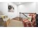 Comfortable sitting area by the stairs with decorative chairs and artwork at 9135 Selborne Ln, Chattahoochee Hills, GA 30268