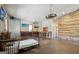 Spacious bedroom featuring unique wagon wheel chandelier, entertainment center and accent wall at 3630 Jim Moore Rd, Dacula, GA 30019