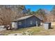 View of the home's exterior showcasing gray siding, utility shed, and a well-maintained lawn with surrounding trees at 3630 Jim Moore Rd, Dacula, GA 30019