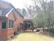 View of backyard with covered brick patio and mature trees at 9255 Betony Wood Trl, Jonesboro, GA 30236