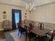 Refined dining room with a dark wood table, chandelier, and striped chairs, perfect for formal dining and entertaining at 9255 Betony Wood Trl, Jonesboro, GA 30236