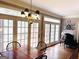 Bright dining room with hardwood floors, black chairs, a wood table, and multiple French doors at 9255 Betony Wood Trl, Jonesboro, GA 30236