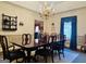 Sophisticated dining room with a dark wood table, chandelier, and an adjacent living area for seamless entertaining at 9255 Betony Wood Trl, Jonesboro, GA 30236
