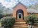 Charming brick home featuring a beautiful arched entrance, manicured bushes, and a welcoming front entrance at 9255 Betony Wood Trl, Jonesboro, GA 30236