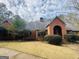 Attractive brick home boasts a well-maintained lawn, mature trees, and classic architectural detailing on a sunny day at 9255 Betony Wood Trl, Jonesboro, GA 30236