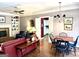 Living room featuring a red sofa, fireplace, built-in shelves, and a dining table with a chandelier at 9255 Betony Wood Trl, Jonesboro, GA 30236