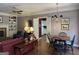 Living room featuring a red sofa, fireplace, built-in shelves, and a dining table with a chandelier at 9255 Betony Wood Trl, Jonesboro, GA 30236