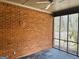 Brick walled patio features ceiling fan and view of the trees outside the window at 9255 Betony Wood Trl, Jonesboro, GA 30236