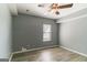 Bedroom showcasing gray walls, a window for natural light, wood laminate flooring, and a ceiling fan at 5365 Renault St, Cumming, GA 30041