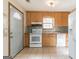 Traditional-style kitchen with wooden cabinets, white appliances, tile backsplash, and easy access to the front door at 5365 Renault St, Cumming, GA 30041