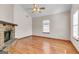 Bright living room with wood laminate flooring, a stone fireplace, large windows, and a ceiling fan at 5365 Renault St, Cumming, GA 30041