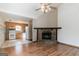 Open-concept living space with hardwood floors, a stone fireplace, and view of the adjacent kitchen at 5365 Renault St, Cumming, GA 30041