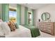 Comfortable bedroom featuring a decorative bed and a wood dresser with circular mirror at 588 Parnassus Road, Locust Grove, GA 30248