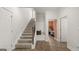 Inviting entryway featuring carpeted stairs, bench seating, and wood-look floors at 588 Parnassus Road, Locust Grove, GA 30248