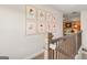 Upstairs hallway featuring decorative floral prints and a view into the living room with an orange accent wall at 588 Parnassus Road, Locust Grove, GA 30248