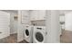Convenient laundry room with modern washer and dryer, white cabinets, and open shelving at 588 Parnassus Road, Locust Grove, GA 30248