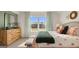 Bedroom with a bed with decorative pillows and a dresser next to a window at 588 Parnassus Road, Locust Grove, GA 30248