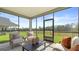 Cozy screened-in porch featuring comfortable seating and serene views of the lush backyard and neighboring trees at 588 Parnassus Road, Locust Grove, GA 30248