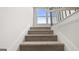 Carpeted staircase with white molding and natural light at 588 Parnassus Road, Locust Grove, GA 30248