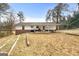 The house back exterior with a patio and wooded backyard on a sunny day at 4601 Highway 81 E, Mcdonough, GA 30252