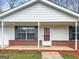 Inviting home's entrance with brick accents, white columns, and a storm door at 4601 Highway 81 E, Mcdonough, GA 30252