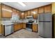 Well-lit kitchen with stainless steel appliances, wood cabinetry, and sleek vinyl floors at 4601 Highway 81 E, Mcdonough, GA 30252