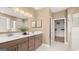 Bathroom showcasing double sinks with granite countertops, large mirror with vanity lighting, and large closet at 600 Parnassus Rd, Locust Grove, GA 30248